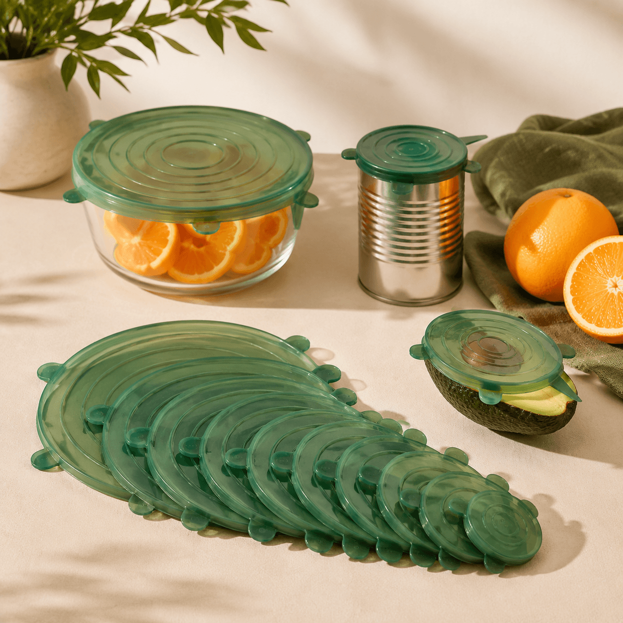 Twelve graduated green silicone stretch lids sealing bowls jars and cut fruit